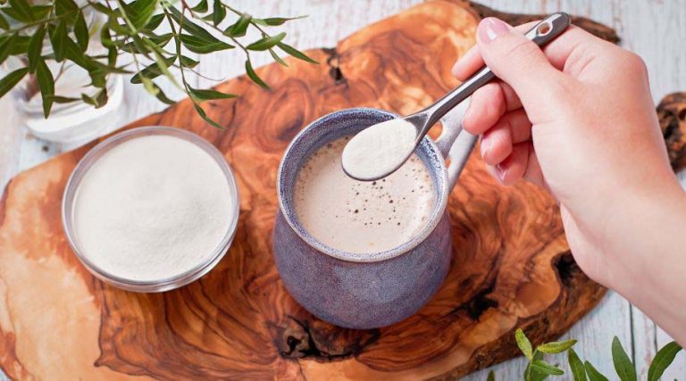 A person adding a spoonful of collagen to their coffee.