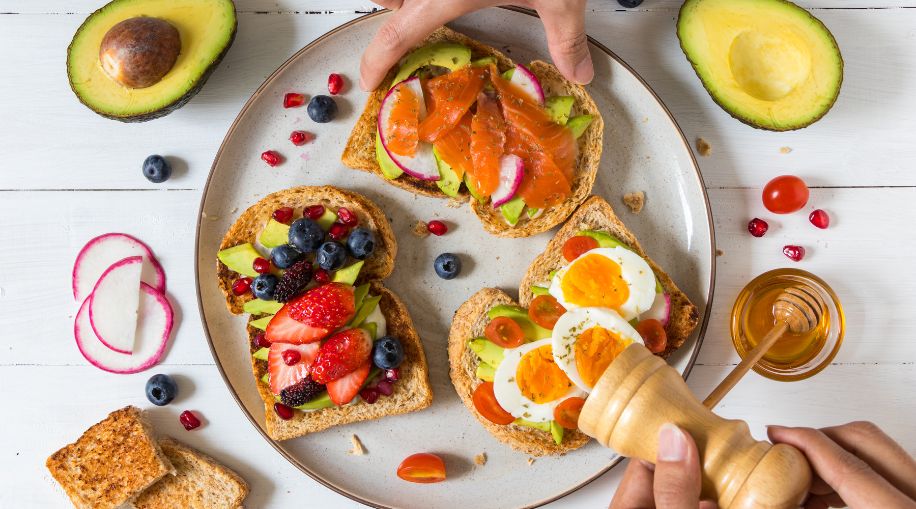 A plate with three pieces of toast, covered in berries, eggs, and other healthy toppings.